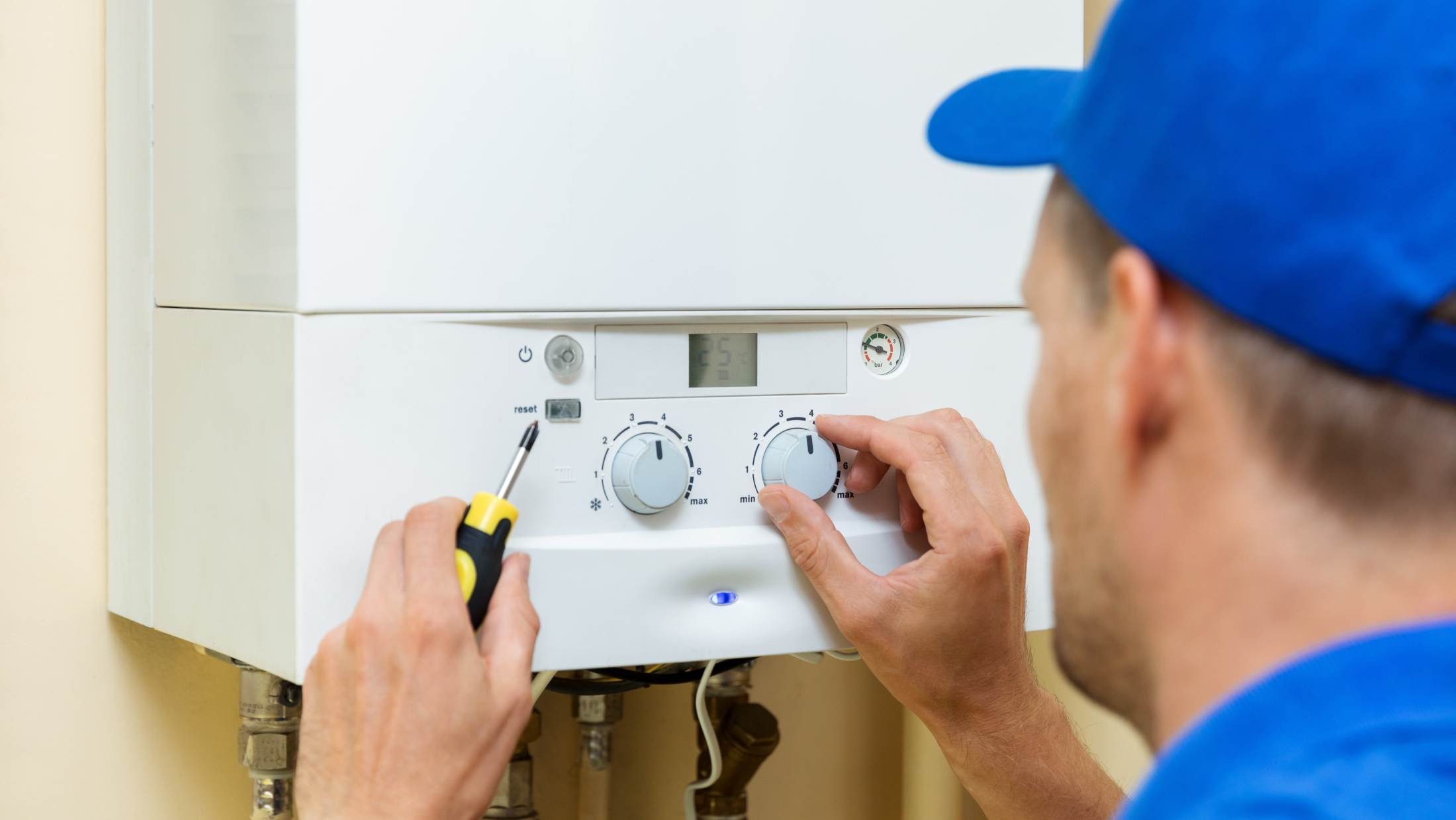 Worker setting up central gas heating boiler
