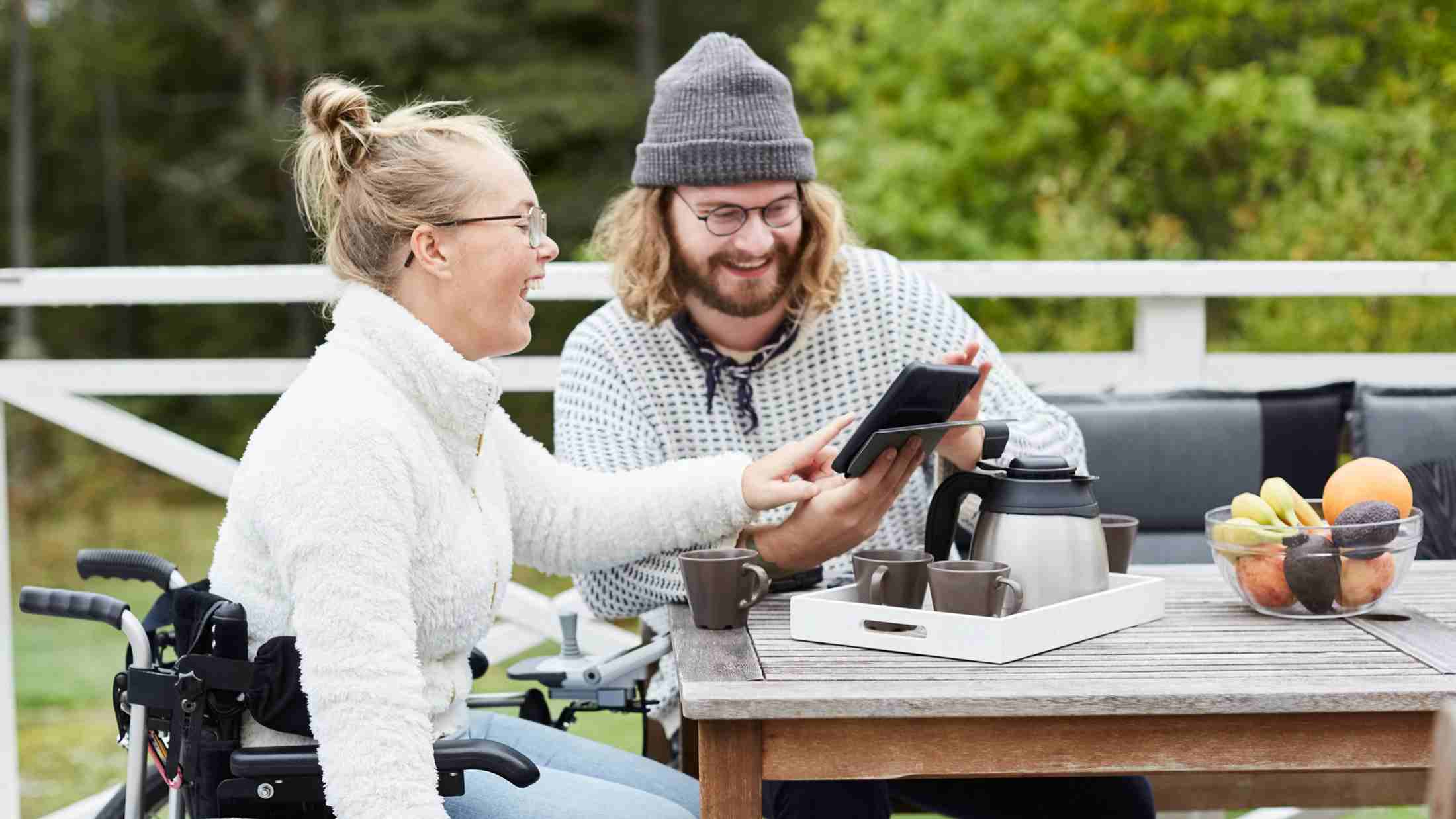 Woman on wheelchair having tea with a male