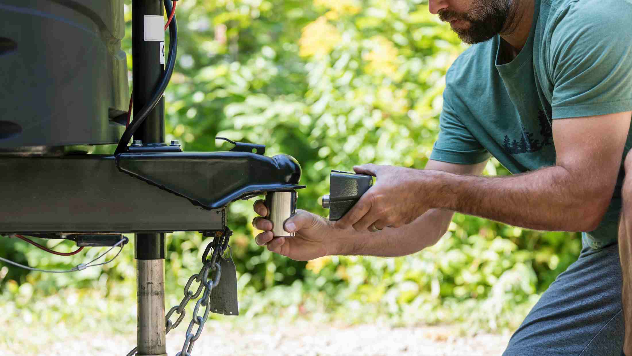 Man installing camper trailer padlock